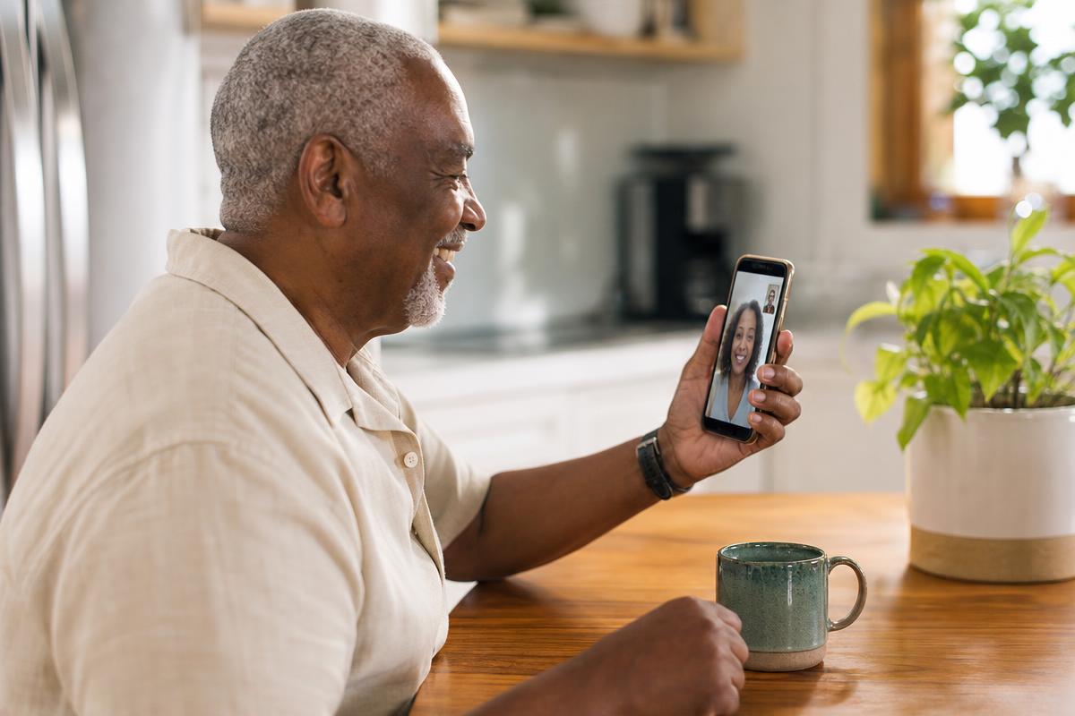 Older adult using a smartphone confidently for a video call.